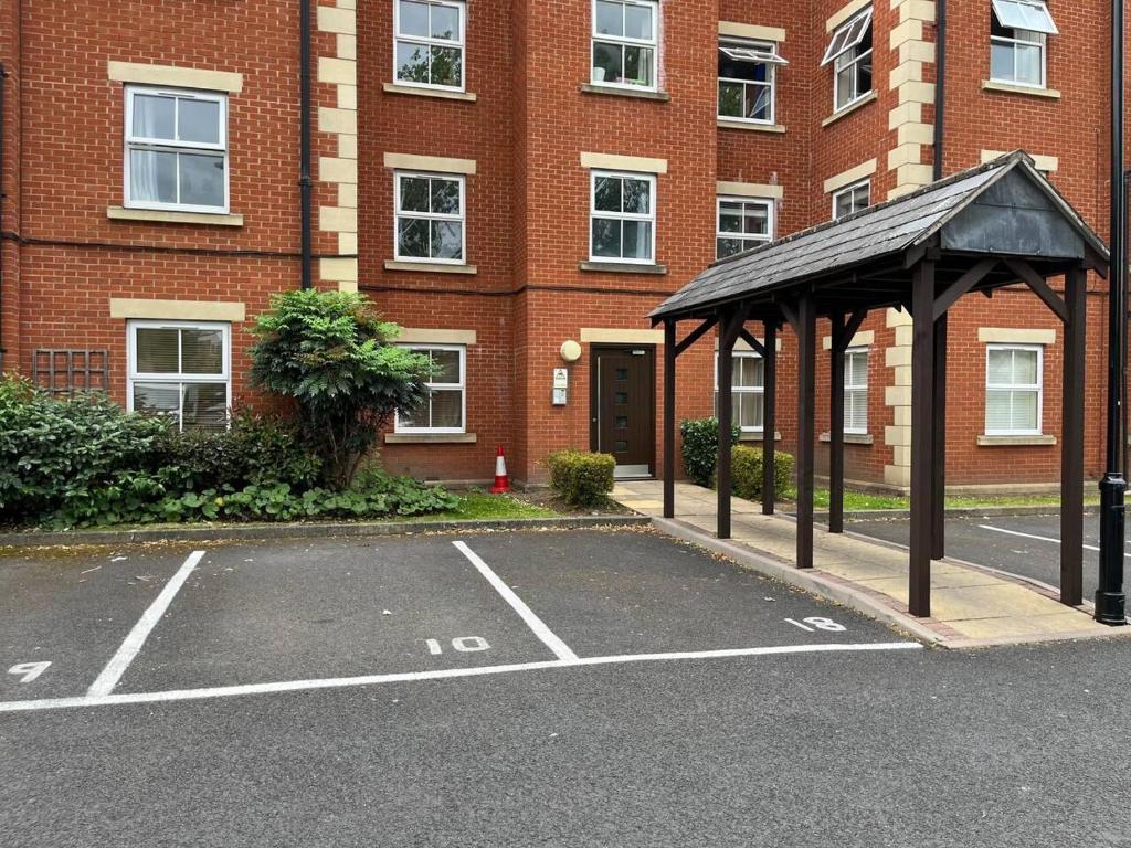 um parque de estacionamento com um gazebo em frente a um edifício em Spacious Apartment Near Birmingham Centre and NeC em Birmingham