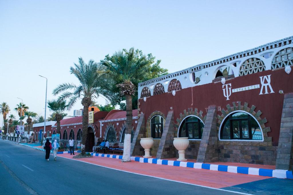 um edifício vermelho no lado de uma rua em Tuya Hotel em Abu Simbel