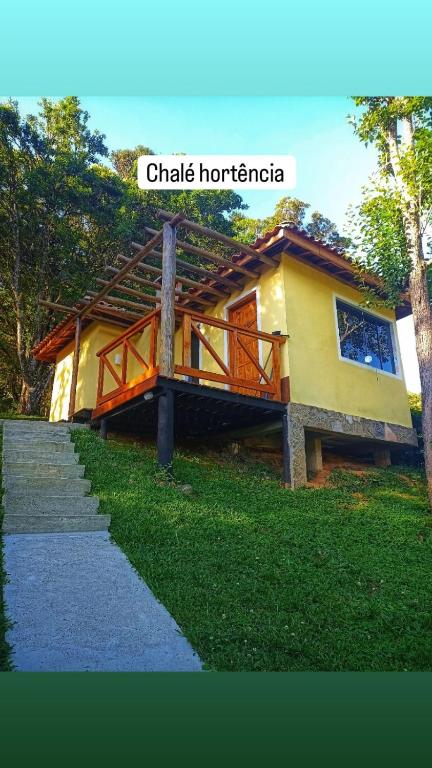 a house with a sign that reads chalky horatio at Chalés Cachoeira do Vale in Camanducaia