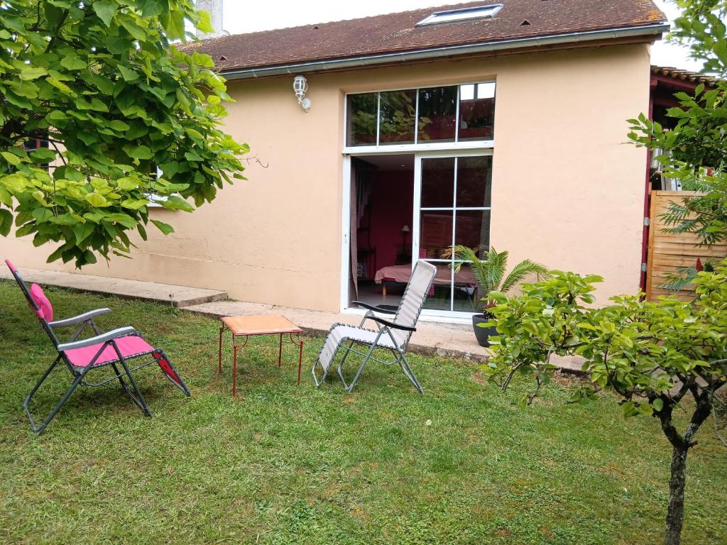 a group of chairs sitting in the grass in front of a house at LA BARAQUE 