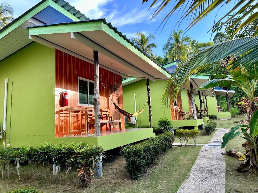 a green and red house with a table and chairs at Suan Nai Kokut Resort in Ko Kood
