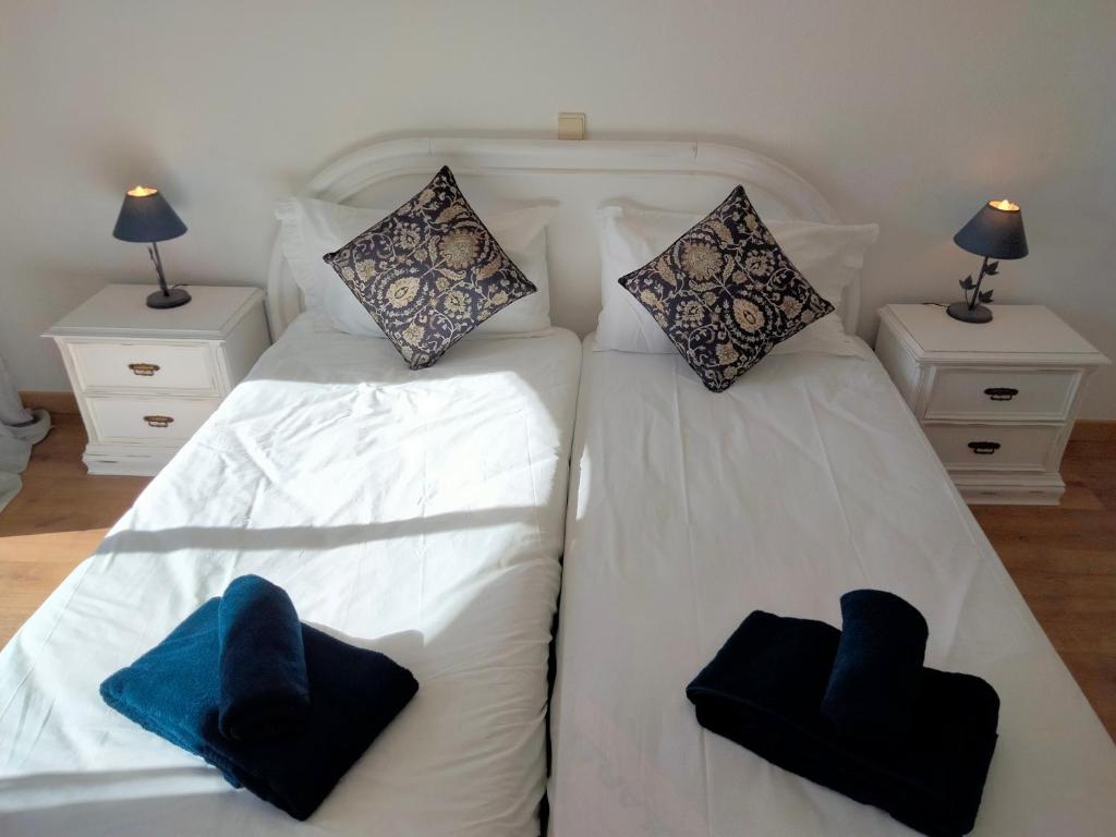 um quarto com 2 camas brancas com almofadas em Lovely 2-bedroom in Carvoeiro free parking em Poço Partido