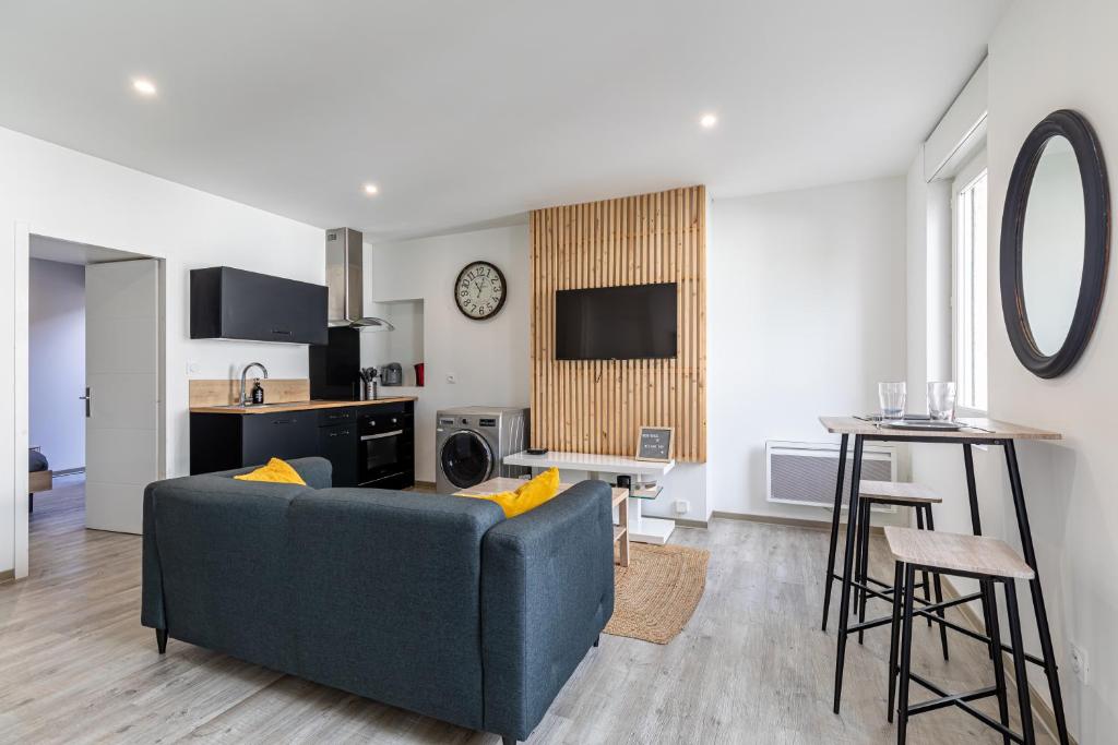 a living room with a blue couch and a kitchen at Le Besson BEY II - Appartement T2 avec extérieur in Angoulême