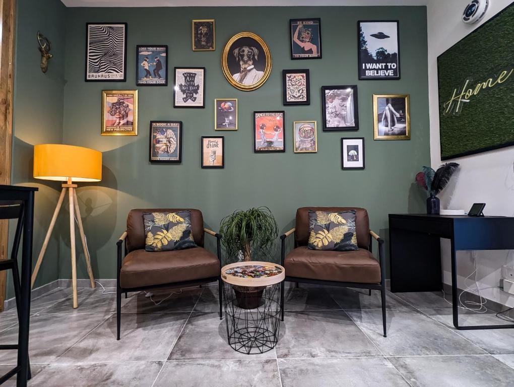 una sala de espera con 2 sillas y cuadros en la pared en Amari home, en Catania