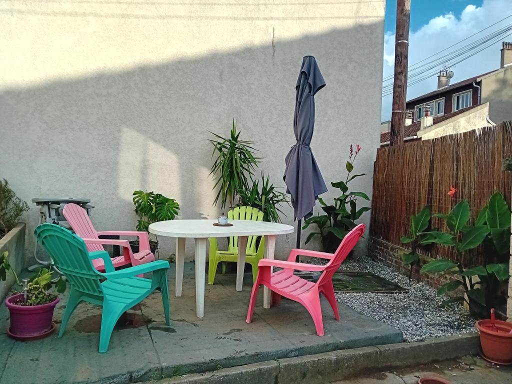 a table and four chairs sitting next to a wall at une maison en ville in Saint-Denis