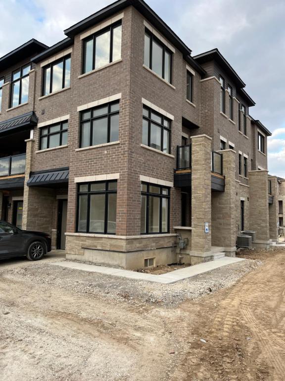 uma casa de tijolos com um carro estacionado em frente em Luxury Brand New Townhouse In Milton Ontario em Milton