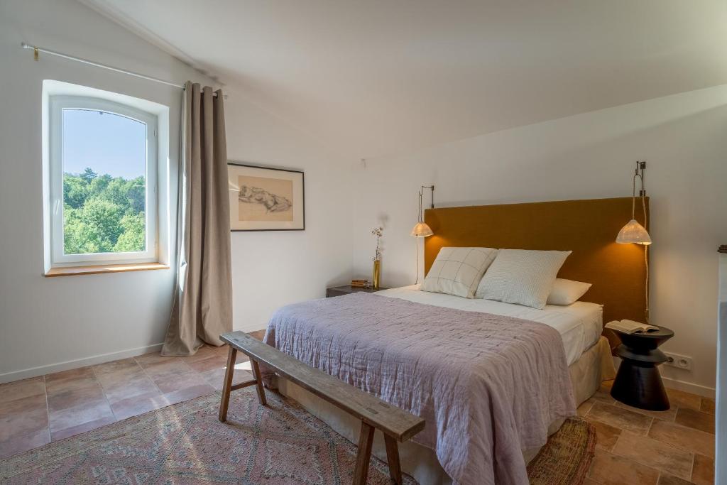 een slaapkamer met een groot bed en een raam bij Villa Vauvert in Saignon