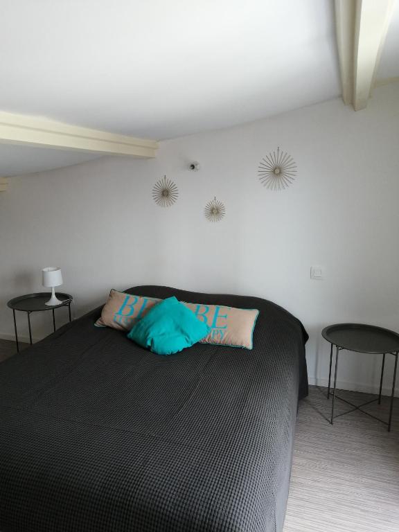 - une chambre avec un lit noir et 2 chaises noires dans l'établissement Au Bon ENdrOIT, à Barneville-Carteret