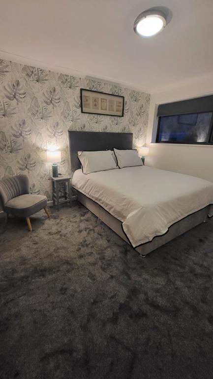 a bedroom with a large bed and a chair at The bolt in Newhaven