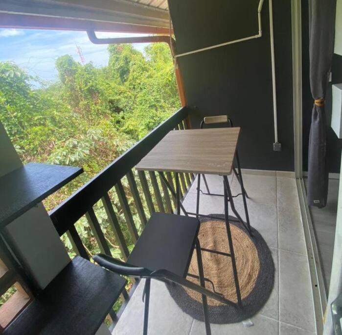 a balcony with a wooden table and a chair at Quiet Place in Cayenne