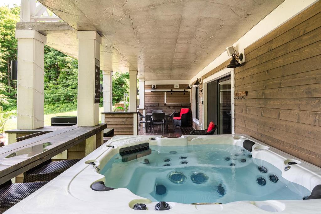 uma banheira de hidromassagem na parte de trás de uma casa em Gîte avec spa Shefford em Shefford