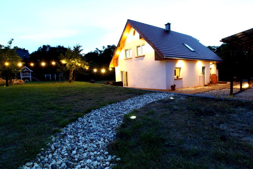 une petite maison blanche avec une allée en gravier dans l'établissement Dobre Miejsce, à Międzyzdroje