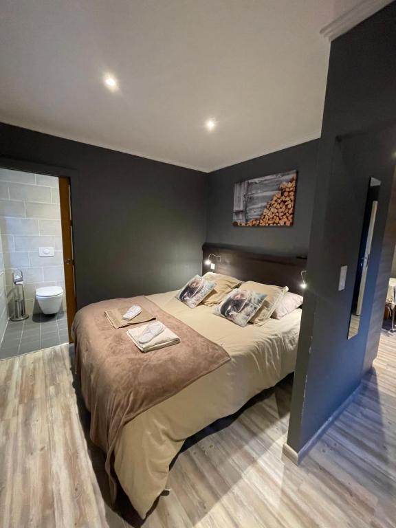 a bedroom with a large bed and a bathroom at la Montagnette L ours T1 in Moutiers