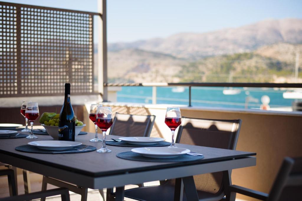 a table with wine glasses and a bottle of wine at Centro Y Mar! Central Penthouse with Terrace! in Argostoli