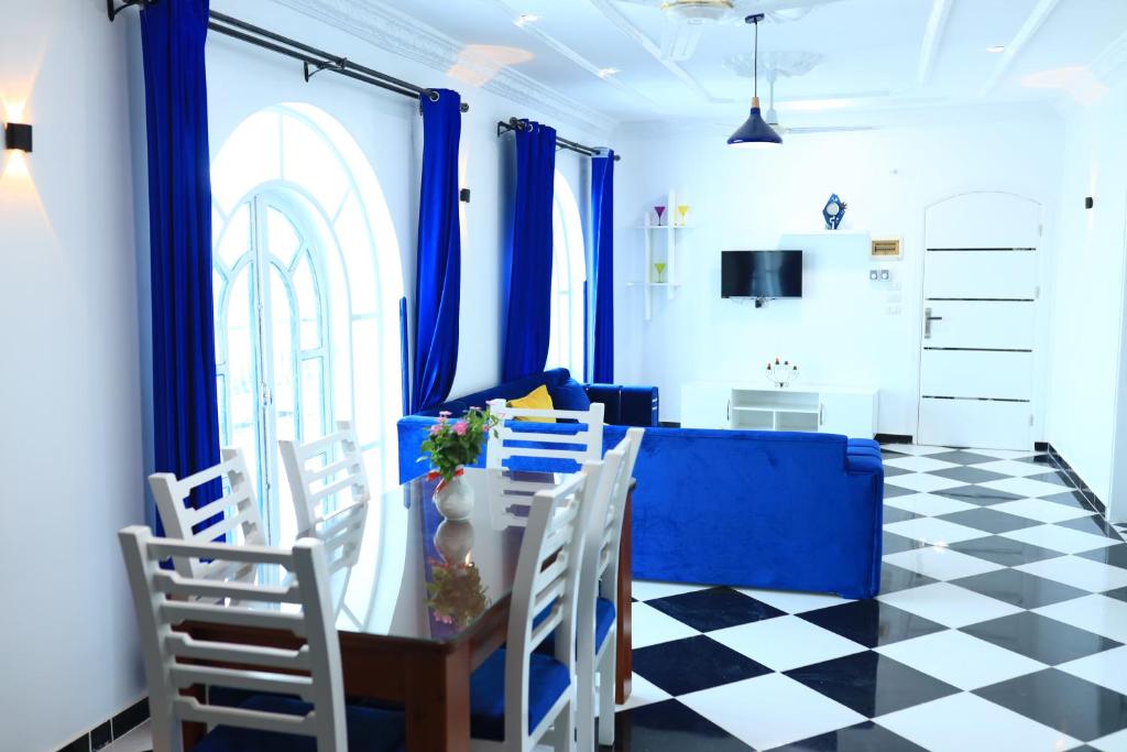 a dining room with blue curtains and a table and chairs at Villa Kaslan Apartments in Luxor