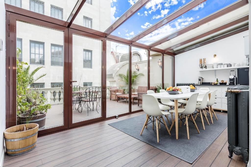 Home Suite Home Gran Via في مدريد: مطبخ وغرفة طعام مع سقف زجاجي كبير