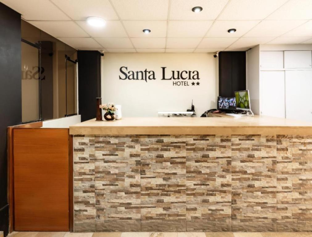 un mostrador de recepción de la oficina con un cartel que diga Santa Lucica en Hotel Santa Lucia - Oficial, en Piura