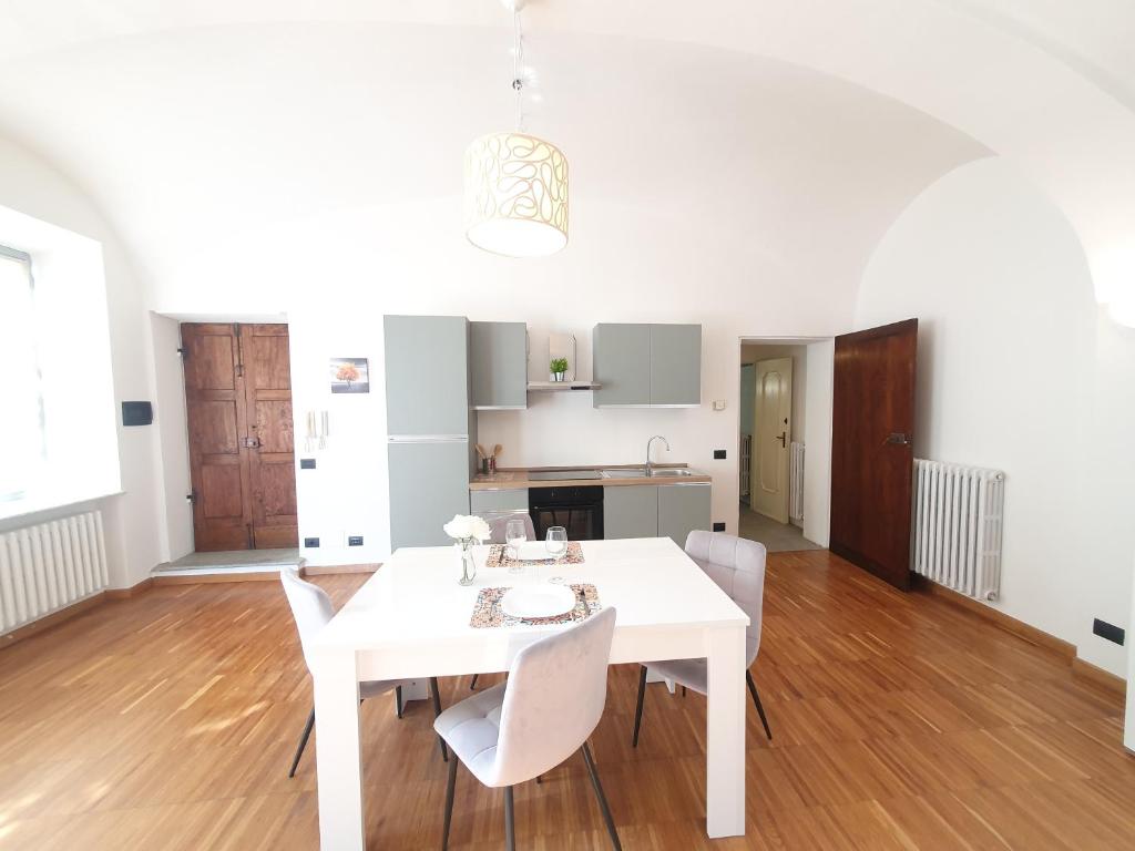 un comedor blanco con una mesa y sillas blancas en Grisella Grace Home en Casale Monferrato