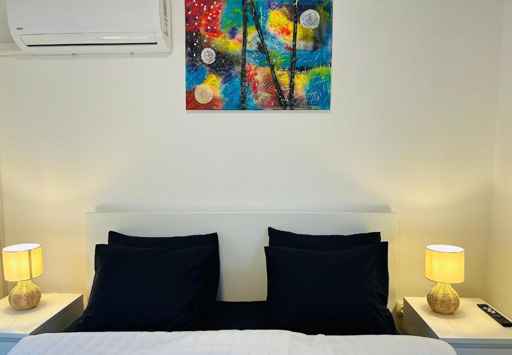 a bedroom with a bed with two lamps and a painting at Apartment In Time in Sesvete