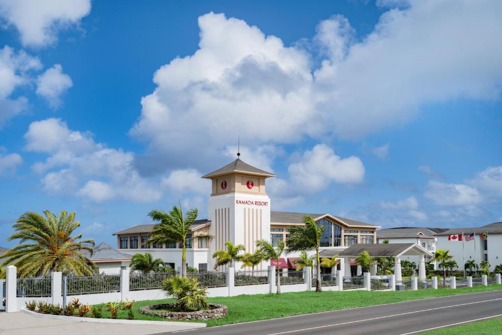 a building with a clock tower in front of a road at Ramada by Wyndham St Kitts Resort 
