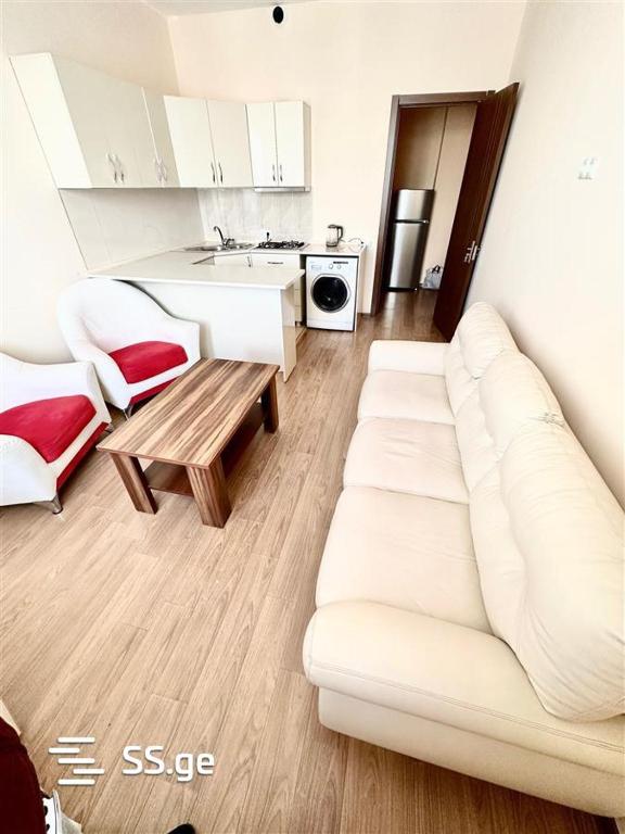 ein Wohnzimmer mit einem weißen Sofa und einem Tisch in der Unterkunft Agmashenebeli112 in Kutaissi