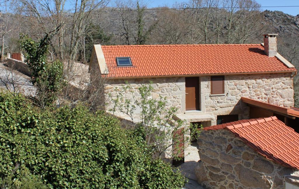 una casa de piedra con techo naranja en Casa do Fasco, en Castro Laboreiro