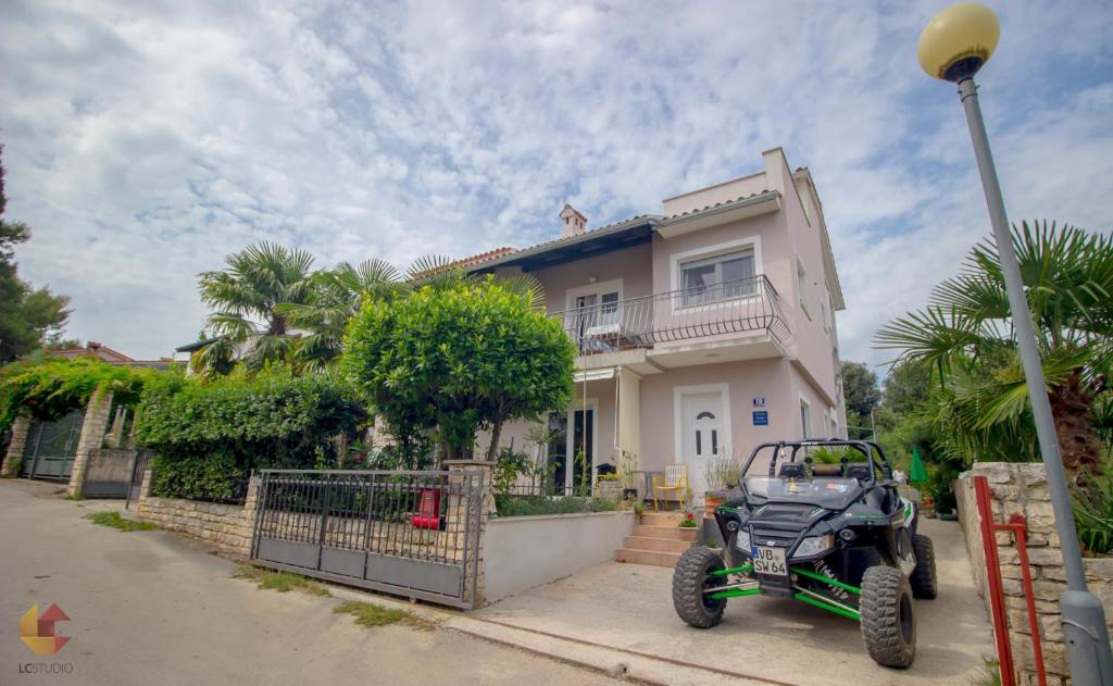 um veículo de quatro rodas estacionado em frente a uma casa em Apartments Mirta em Rovinj