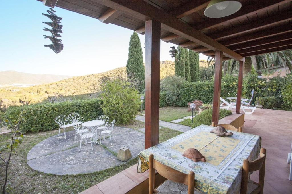 a patio with a table and chairs on a porch at Villetta Bel Giardino in Marina di Campo
