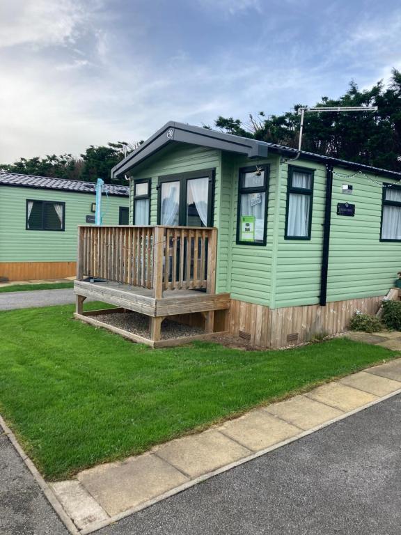 a green house with a bench in the yard at Sunflower Lodge, Lido Leisure Park, Knaresborough in Knaresborough