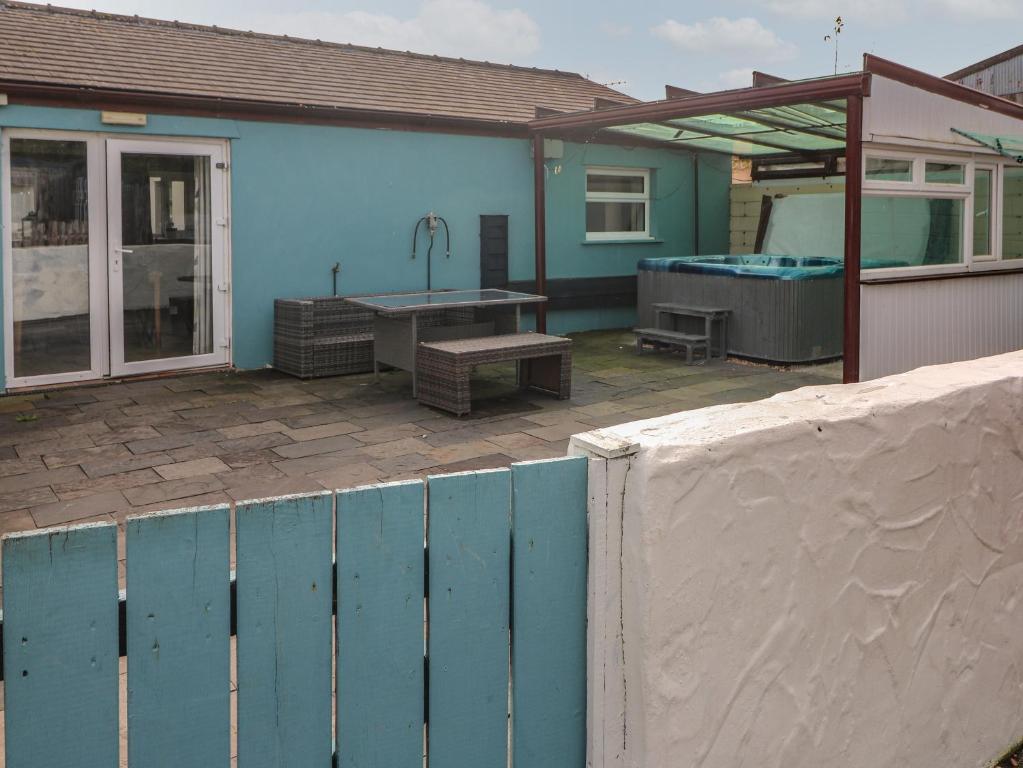 ein blaues Haus mit einem Pool und einem Zaun in der Unterkunft Barn Cottage in Laugharne