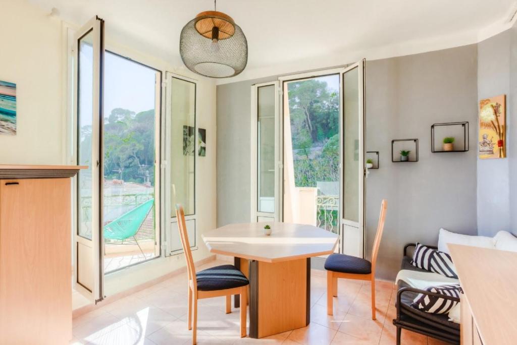 une salle à manger avec une table et des chaises et une fenêtre dans l'établissement LE PALAIS DU CHATEAU PORT DE NICE ANTIQUAIRES, à Nice