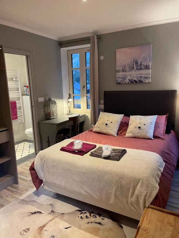 een slaapkamer met een bed met twee dienbladen erop bij la Montagnette l oursson CHAMBRE in Moutiers
