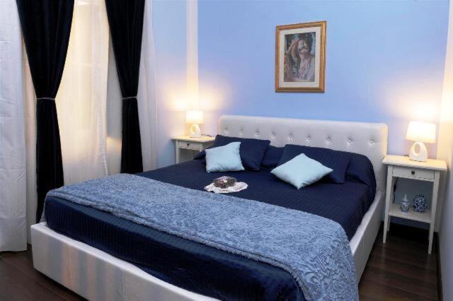 - une chambre bleue dotée d'un grand lit avec des draps bleus dans l'établissement B&B Alexander, à Rome