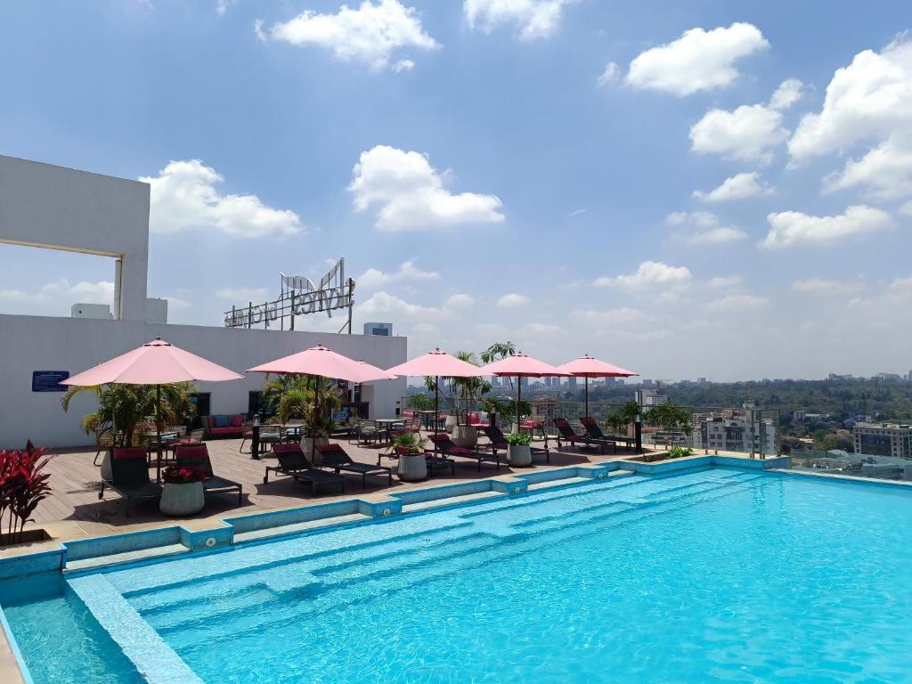 a swimming pool with chairs and umbrellas on a building at Skynest Residences by Lisa's Paradise C in Nairobi