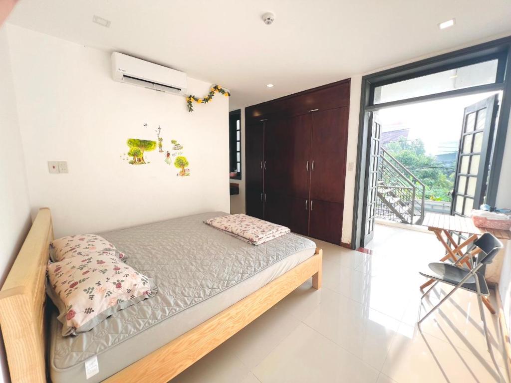een slaapkamer met een bed en een groot raam bij Kenzi Homestay - có cho thuê xe gắn máy, xe đạp in Hue
