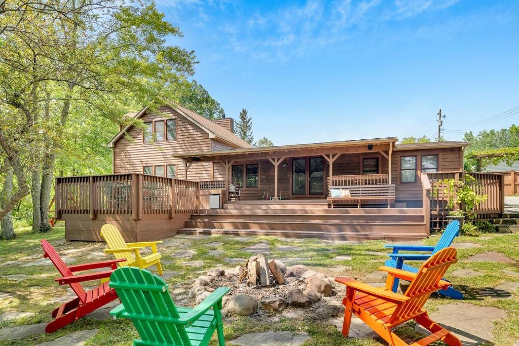 a group of colorful chairs in front of a house at Peaceful Lakefront Cabin Retreat with Hot Tub! 