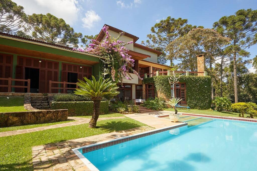 uma casa com piscina em frente a uma casa em Casa Pinheiral em Bragança Paulista
