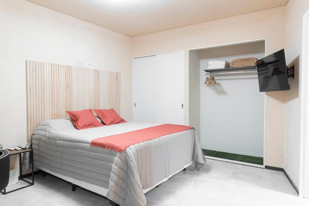 Un dormitorio con una cama con almohadas rojas. en Cañitas Chic, en Buenos Aires