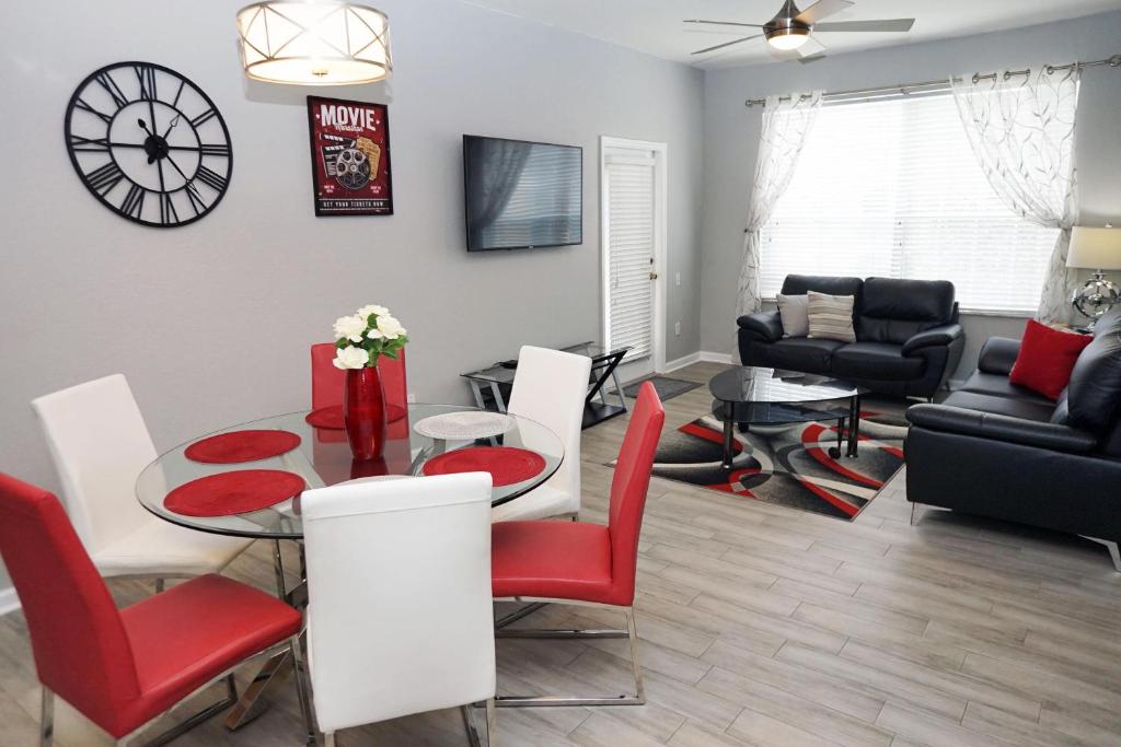 uma sala de estar com uma mesa e cadeiras vermelhas em WH205B 3 BR Windsor Hills Condo! em Orlando