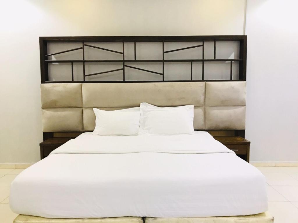 راسيات الحمدانية - Hotel Rasiyat في جدة: سرير أبيض كبير مع ملاءات ووسائد بيضاء