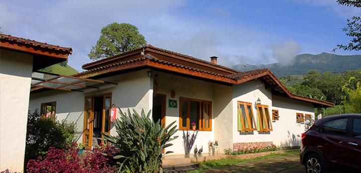 a house with a car parked in front of it at Riacho Doce Pousada in São Francisco Xavier