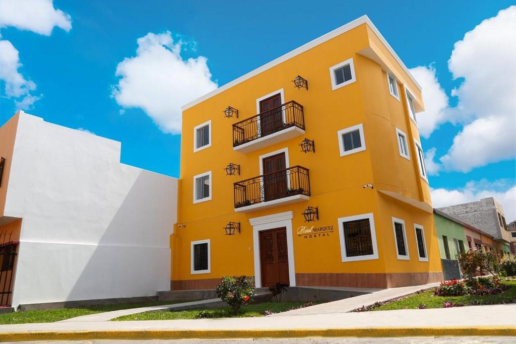 un edificio amarillo con un cielo azul en el fondo en REAL MARQUEZ, en Trujillo