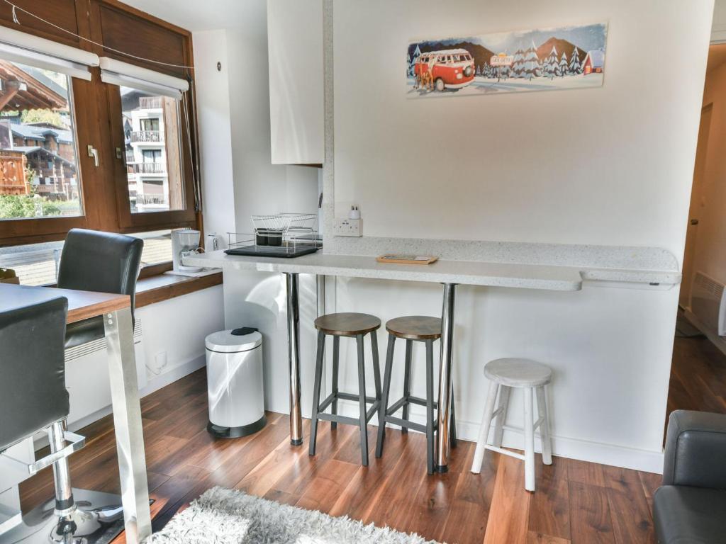 une cuisine avec un comptoir et des tabourets dans une pièce dans l'établissement Studio Cabine Rénové Centre Village - 28m² - Balcon - 3 Pers - Parking - Les Gets - FR-1-685-9, aux Gets