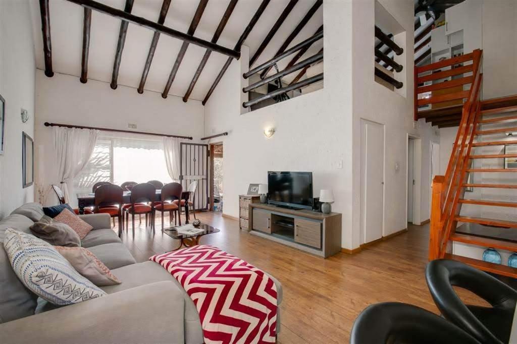 uma sala de estar com um sofá e uma televisão em Paulshof Sandton Apartments - Monchique em Sandown