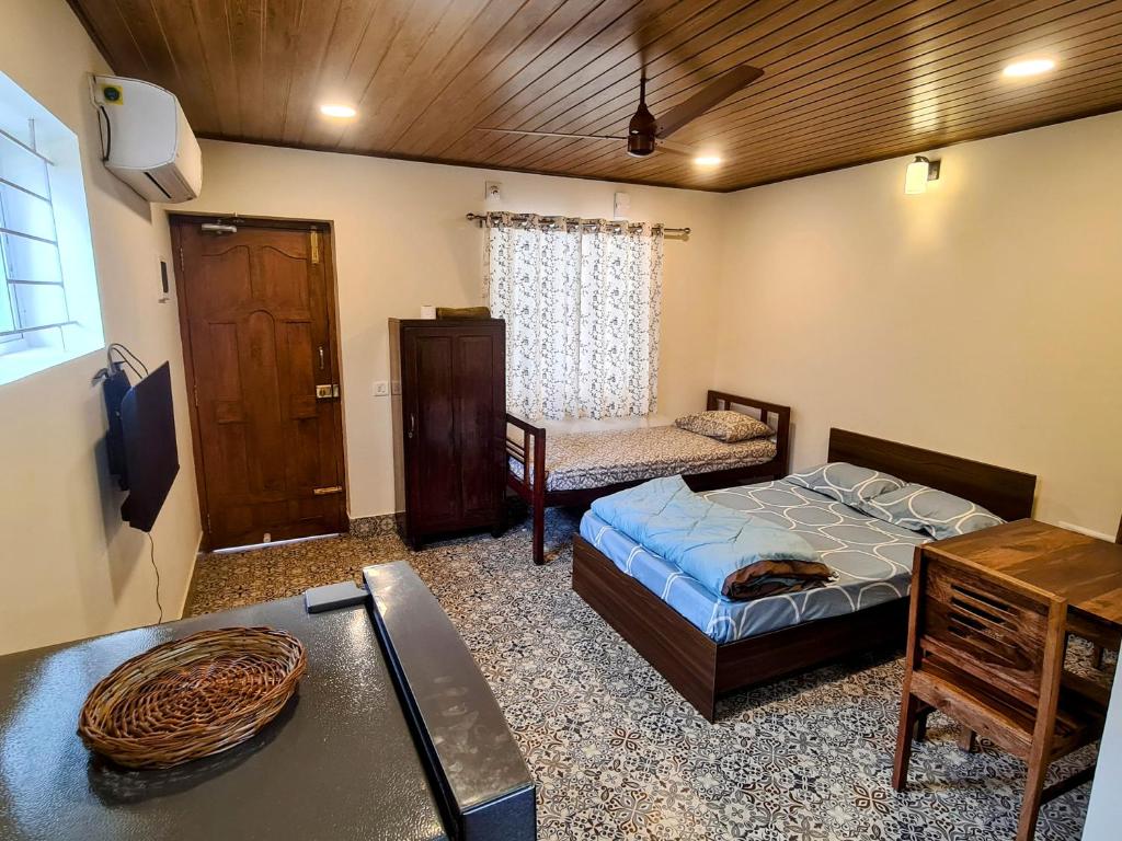 a bedroom with a bed and a desk in a room at Sunny Smiles in Mangalore