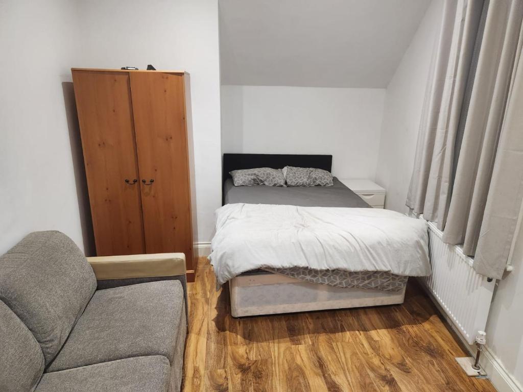 a small bedroom with a bed and a couch at BEAUTIFUL ROOM In LOVELY FLAT in Woolwich