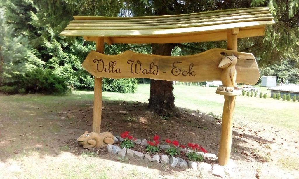 een houten bord in een park met een bord waarop de code 'wild oak' staat bij Ückeritz, Villa Wald-Eck - Erdgeschoss in Ueckeritz