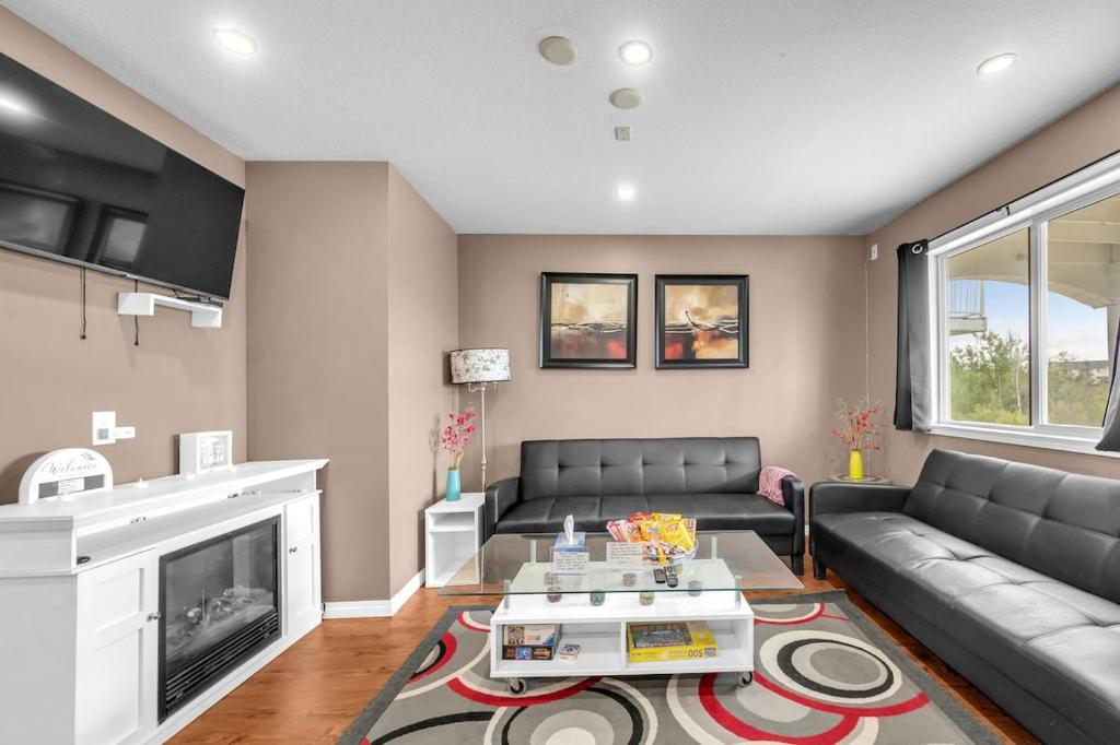 a living room with a couch and a fireplace at 52-3 Bed Suite On Lake Central Ac By Airport in Calgary