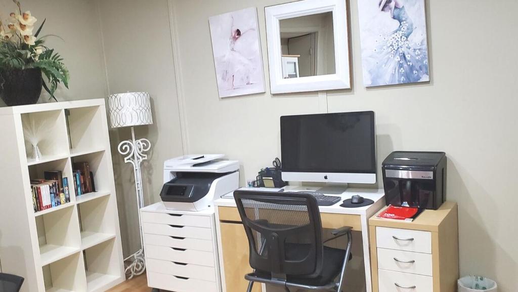a desk with a computer monitor and a printer at 56 Executive Business Home W Ac 10 Min To Airport in Calgary