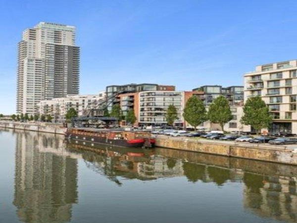 um rio com carros estacionados ao lado de uma cidade em Edouard Boat em Bruxelas